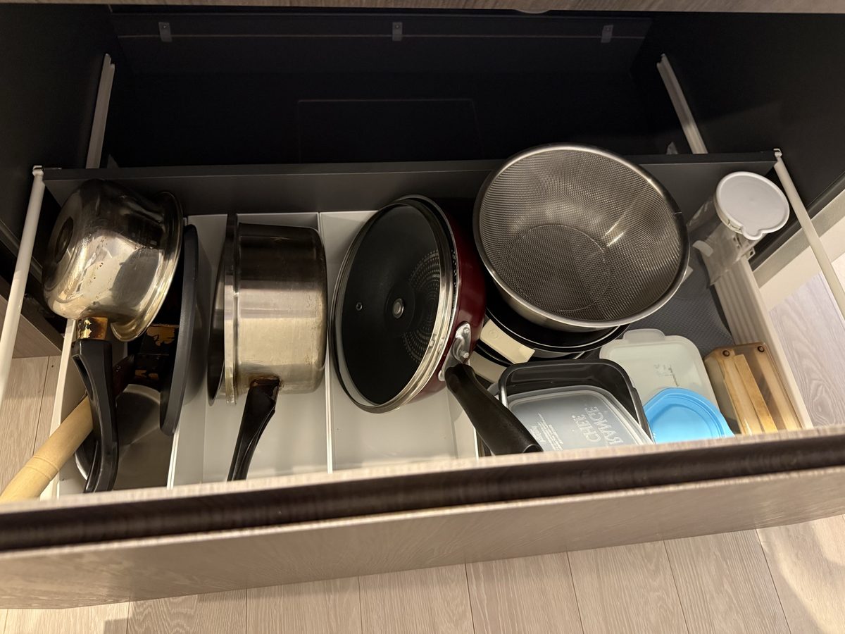 仕切りで分けて鍋やふたを立てて収納した引き出し
