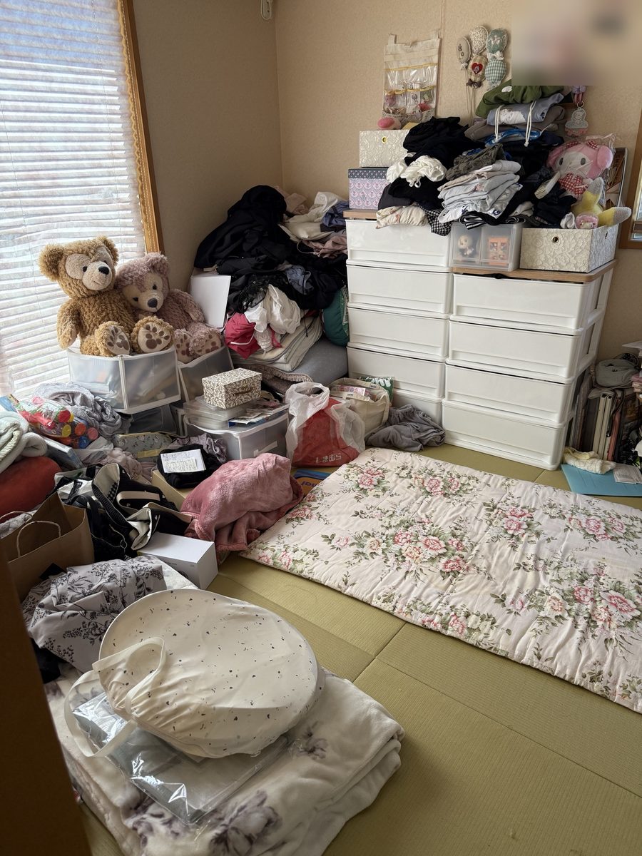 片付ける前の和室。衣類やぬいぐるみ、袋などが畳の上にあふれている